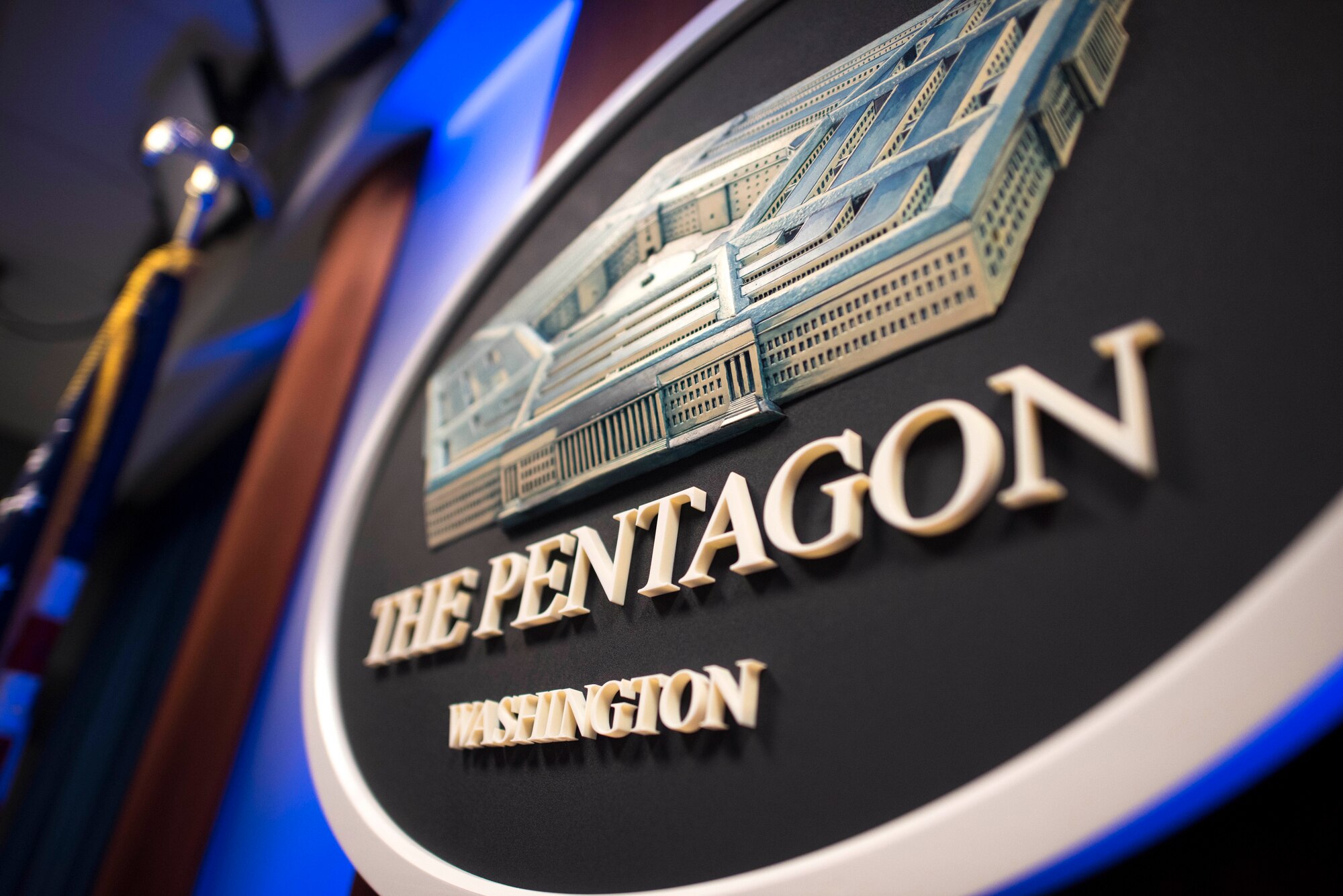 A Pentagon seal hangs on a wall.