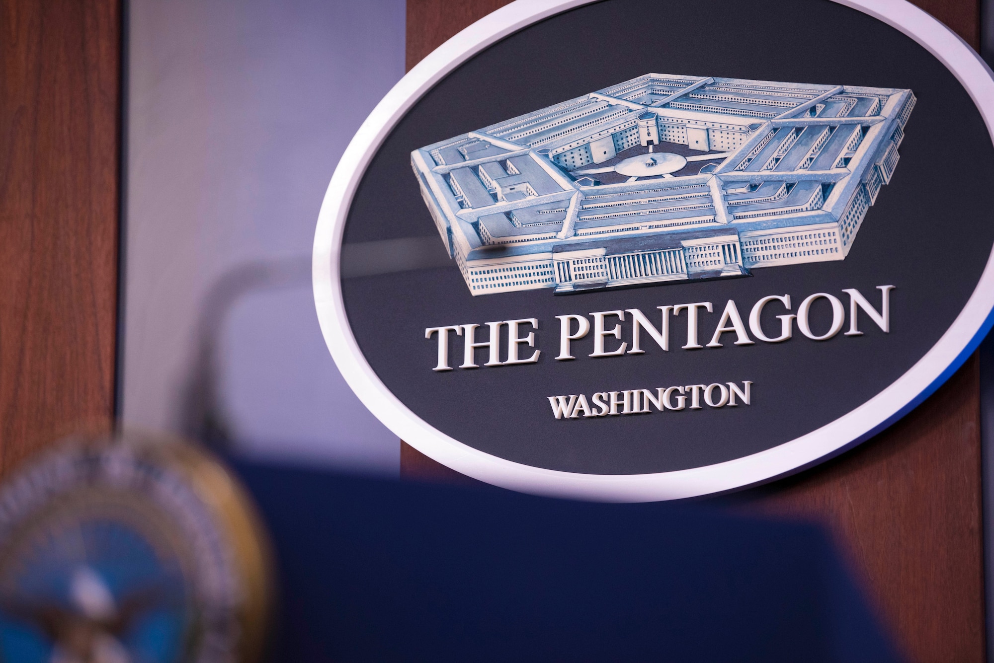 A Pentagon seal hangs on a wall.