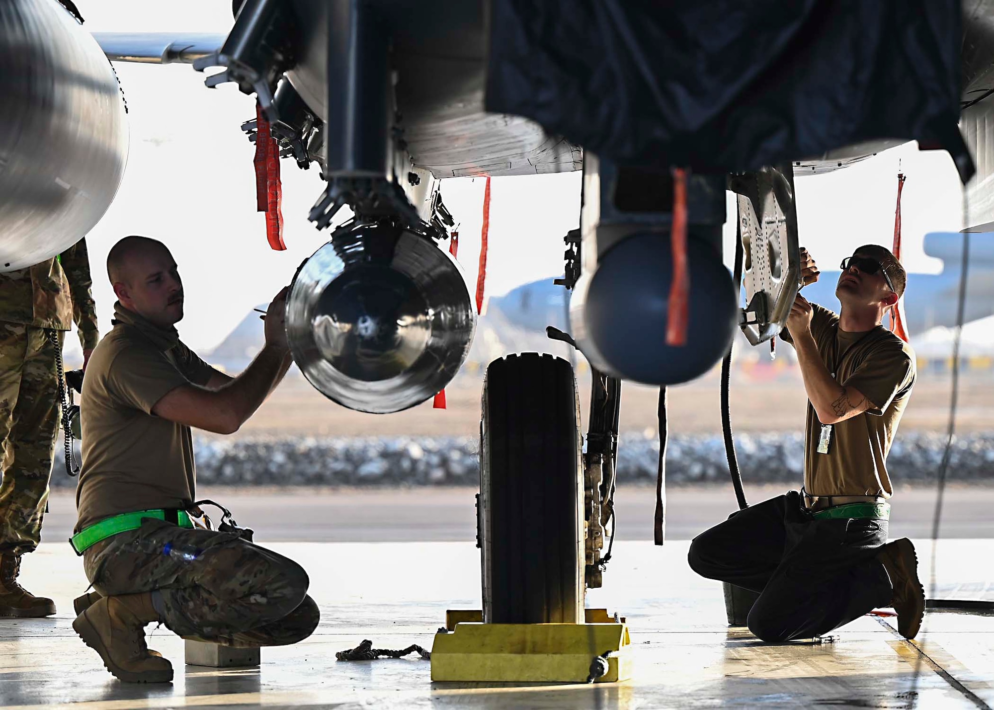 Two U.S. Air Force F-15E Strike Eagle dedicated crew chiefs assigned to the 380th Expeditionary Aircraft Maintenance Squadron (EAMXS) perform maintenance on an F-15E at Al Dhafra Air Base, United Arab Emirates, Jan. 19, 2021.