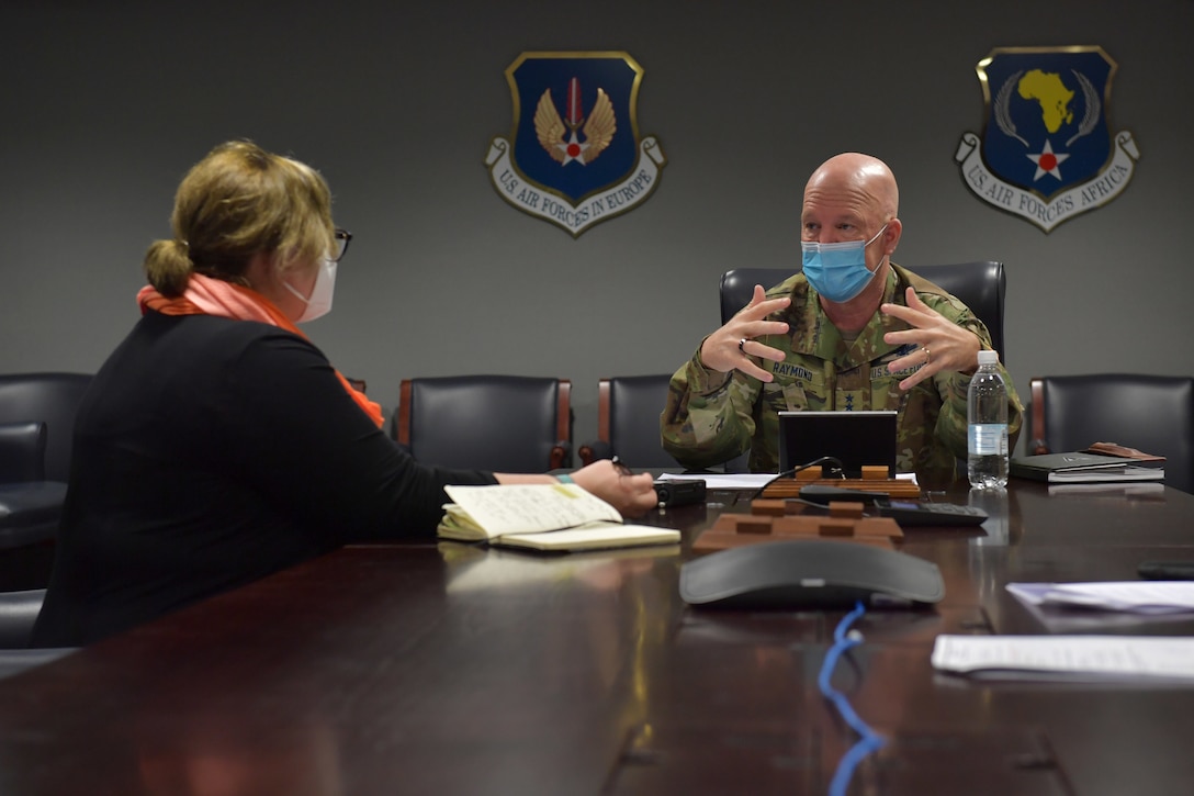 Journalist interviewing a general in a conference room.