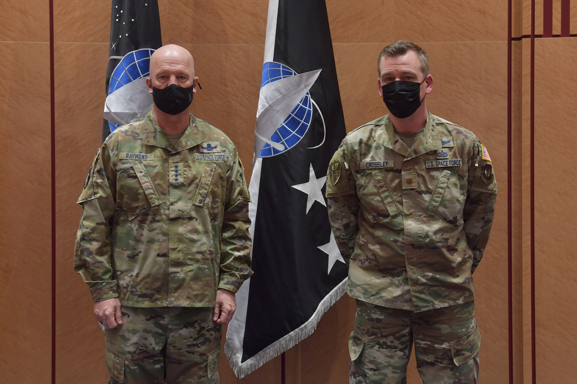 Guardians standing in front of U.S. Space Force flags.