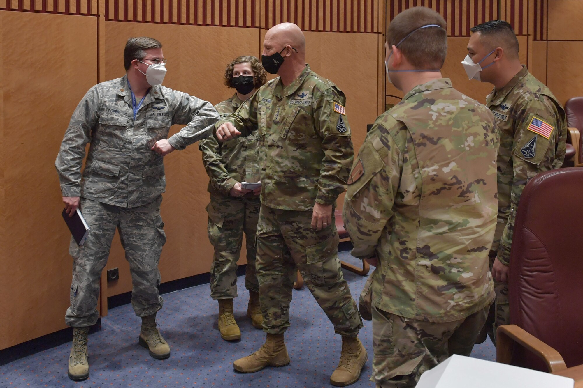 Airman bumping elbows with a general.