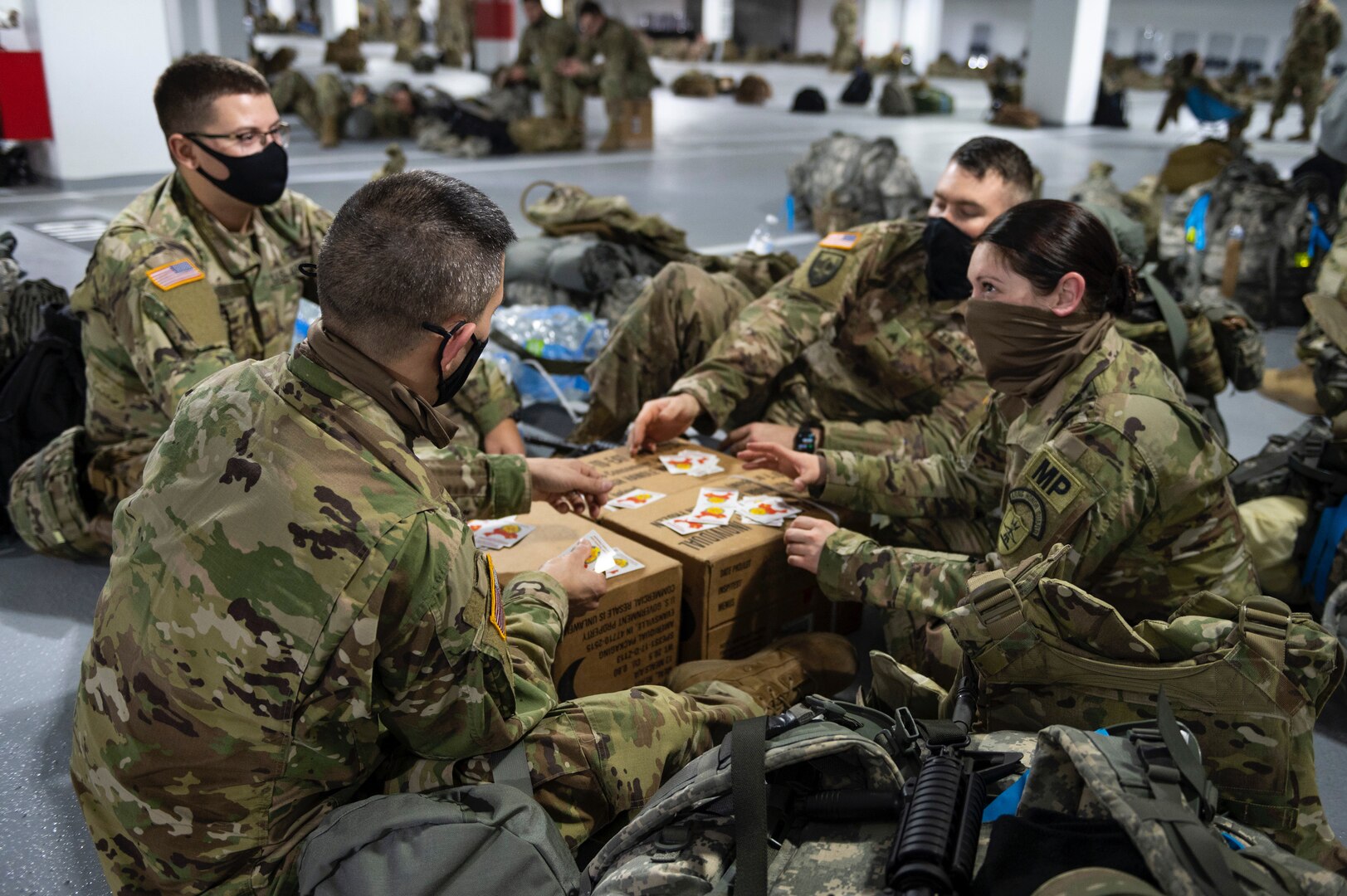 From left: U.S. Army 2nd Lt. Jeremy Wesloh, Sgt. 1st Class Justin Valenti, Sgt. Lucas Zabka, and Staff Sgt. Jessica Fetsch, all with the 191st Military Police Company, North Dakota National Guard, play cards near the U.S. Capitol in Washington Jan. 19, 2021. More than 25,000 National Guard Soldiers and Airmen from throughout the country traveled to Washington to support federal and local authorities for the presidential inauguration. About 7,900 remain in February.