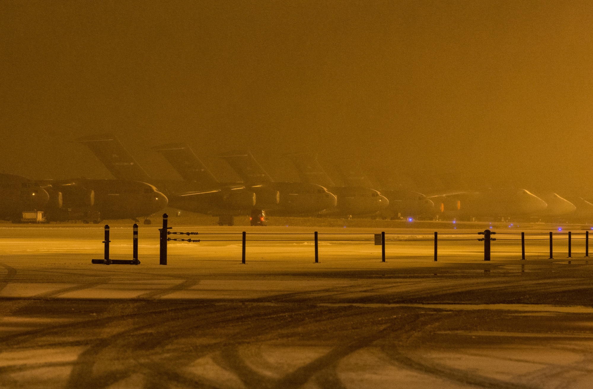 C-17 Globemaster III and C-5M Super Galaxy aircraft sit on the snow-covered flight line at Dover Air Force Base, Delaware, Feb. 1, 2021. As snow fell, the base continued normal operations and prepared for additional forecast snowfall during the next few days. (U.S. Air Force photo by Roland Balik)