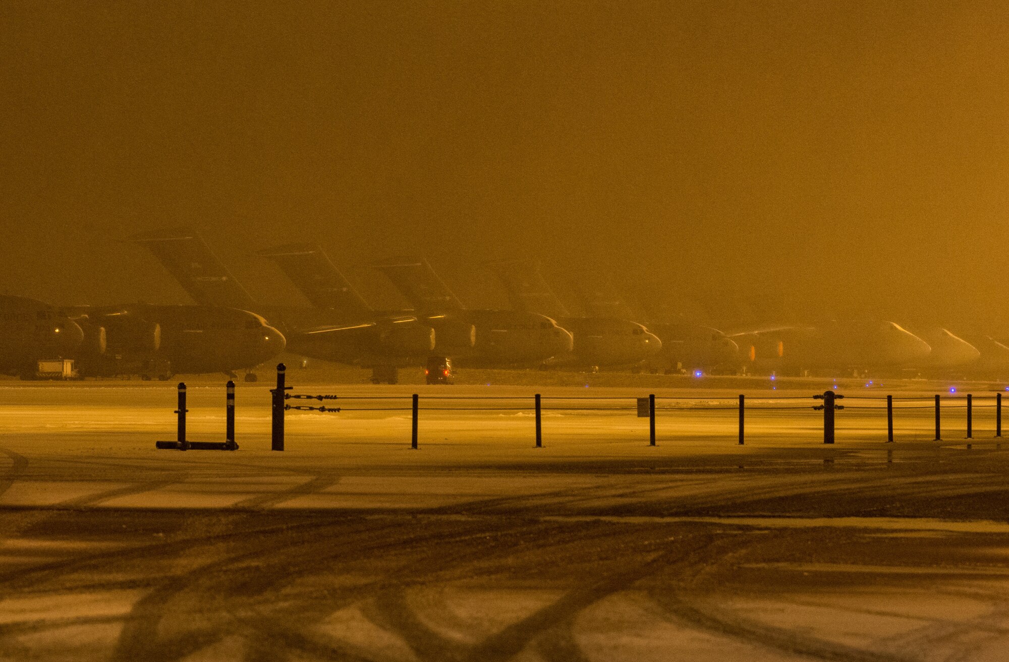 C-17 Globemaster III and C-5M Super Galaxy aircraft sit on the snow-covered flight line at Dover Air Force Base, Delaware, Feb. 1, 2021. As snow fell, the base continued normal operations and prepared for additional forecast snowfall during the next few days. (U.S. Air Force photo by Roland Balik)