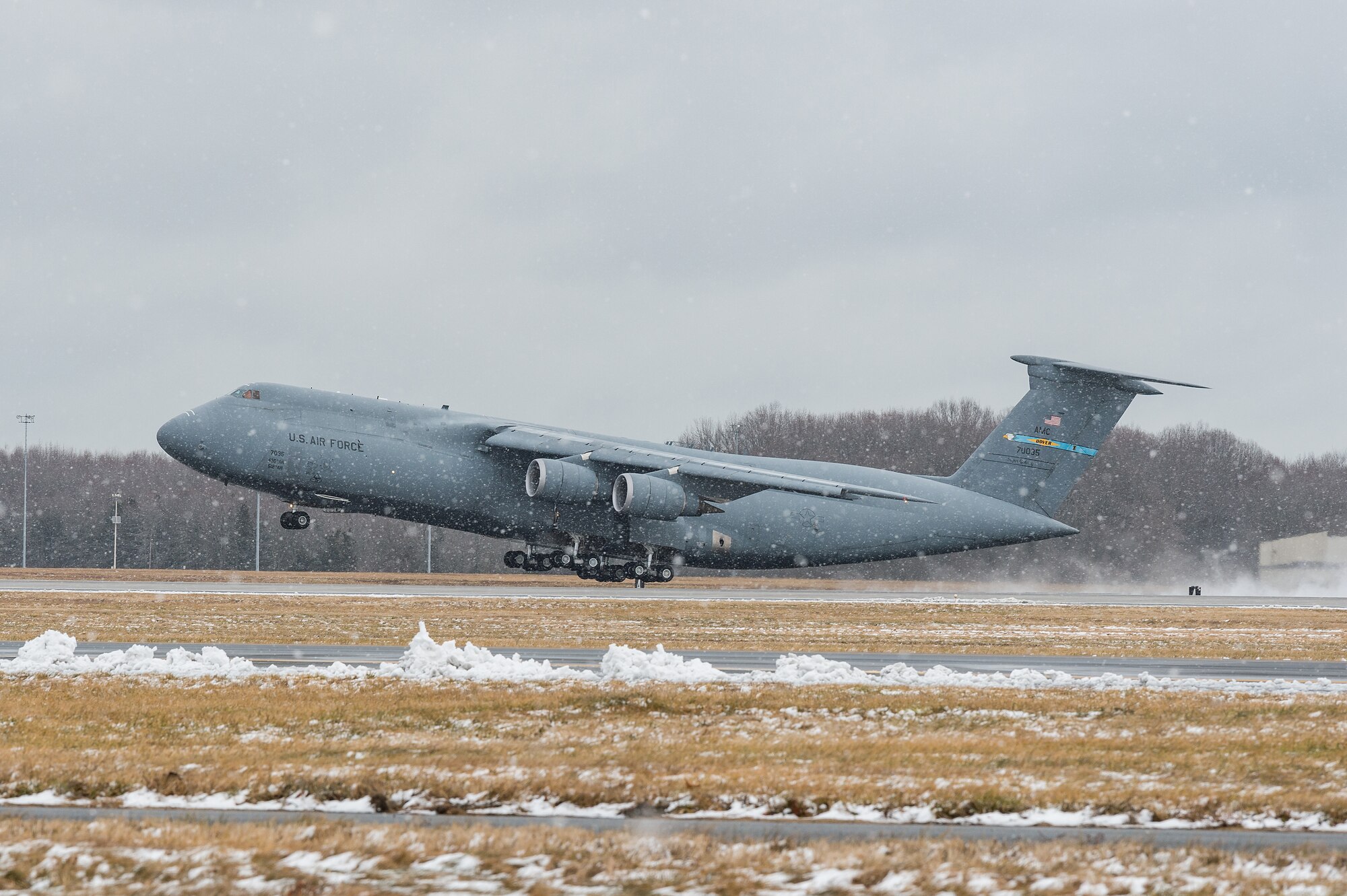 A C-5M Super Galaxy takes off from the runway at Dover Air Force Base, Delaware, Feb. 2, 2021. As snow fell, the base continued normal operations and prepared for additional forecast snowfall during the day. (U.S. Air Force photo by Roland Balik)