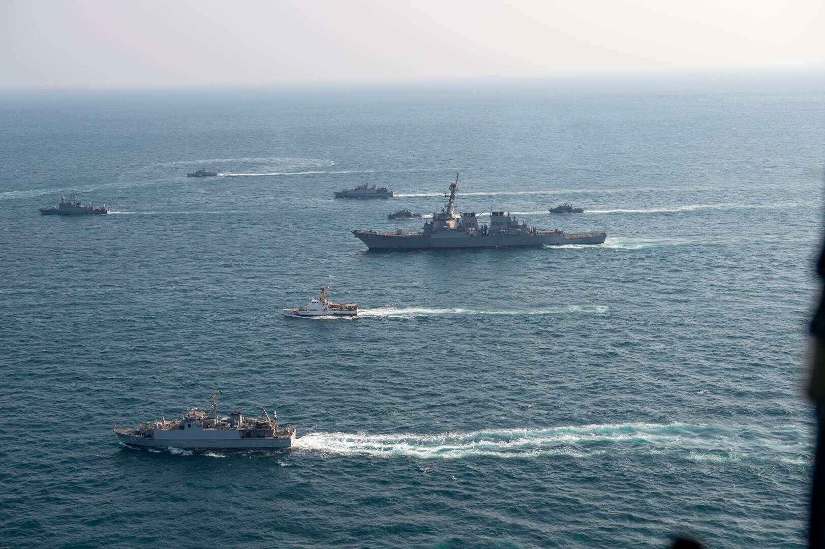 210124-N-XG173-1553 ARABIAN GULF (Jan. 24, 2020) Royal Saudi Naval Force ships and U.S. Navy sail in formation during exercise Nautical Defender (ND) 21 in the Arabian Gulf, Jan. 24. ND 21 is the capstone in a series of multi-national maritime security exercises designed to broaden levels of cooperation, support long-term regional security, and enhance military-to-military interoperability between the Kingdom of Saudi Arabia, UK and the U.S. (U.S. Navy photo by Mass Communication Specialist 2nd Class Aja Bleu Jackson)