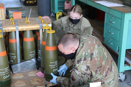 Airman 1st Class Lauren Luttges and Tech Sgt. Roger Van Tassel, both from the California Air National Guard's 144th Fighter Wing in Fresno, inspect howitzer rounds at the Camp Roberts Ammunition Supply Point (ASP), Jan. 26, 2021. Van Tassel and Luttges are supporting the California Army National Guard after several Soldiers at the ASP were quarantined due to COVID-19.