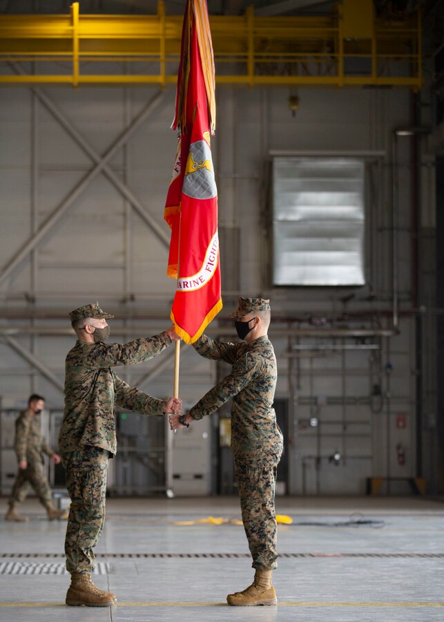 U.S. Marine Corps Lt. Col. Alexander Goodno, the incoming commanding officer, left, and Sgt. Maj. Collin Barry, the incoming sergeant major, with Marine Fighter Attack Squadron (VMFA) 225, Marine Aircraft Group 13, 3rd Marine Aircraft Wing, exchange the organizational colors during the re-designation and assumption of command ceremony at Marine Corps Air Station Yuma, Ariz., Jan. 29, 2021. The ceremony official re-designated Marine All-Weather Fighter Attack Squadron (VMFA(AW) 225 to VMFA-225, signifying the squadron’s transition from the AV-8B Harrier to the F-35B Lightning II. (U.S. Marine Corps photo by Lance Cpl. Juan Anaya)