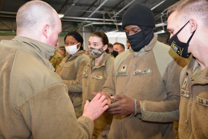 Senior Airman Robert Lydic (left), assigned to 171st Air Refueling Wing, hands Spc. Devonte Crawford (right), assigned to 128th Brigade Support Battalion, 2nd Infantry Brigade Combat Team, a cell phone used in in-processing for troops. Both are members of the Pennsylvania National Guard’s Task Force Panther, a 450-member multi-service task force established to assist federal law enforcement agencies in Washington, D.C. The task force departed Fort Indiantown Gap, Pa., Feb. 3.