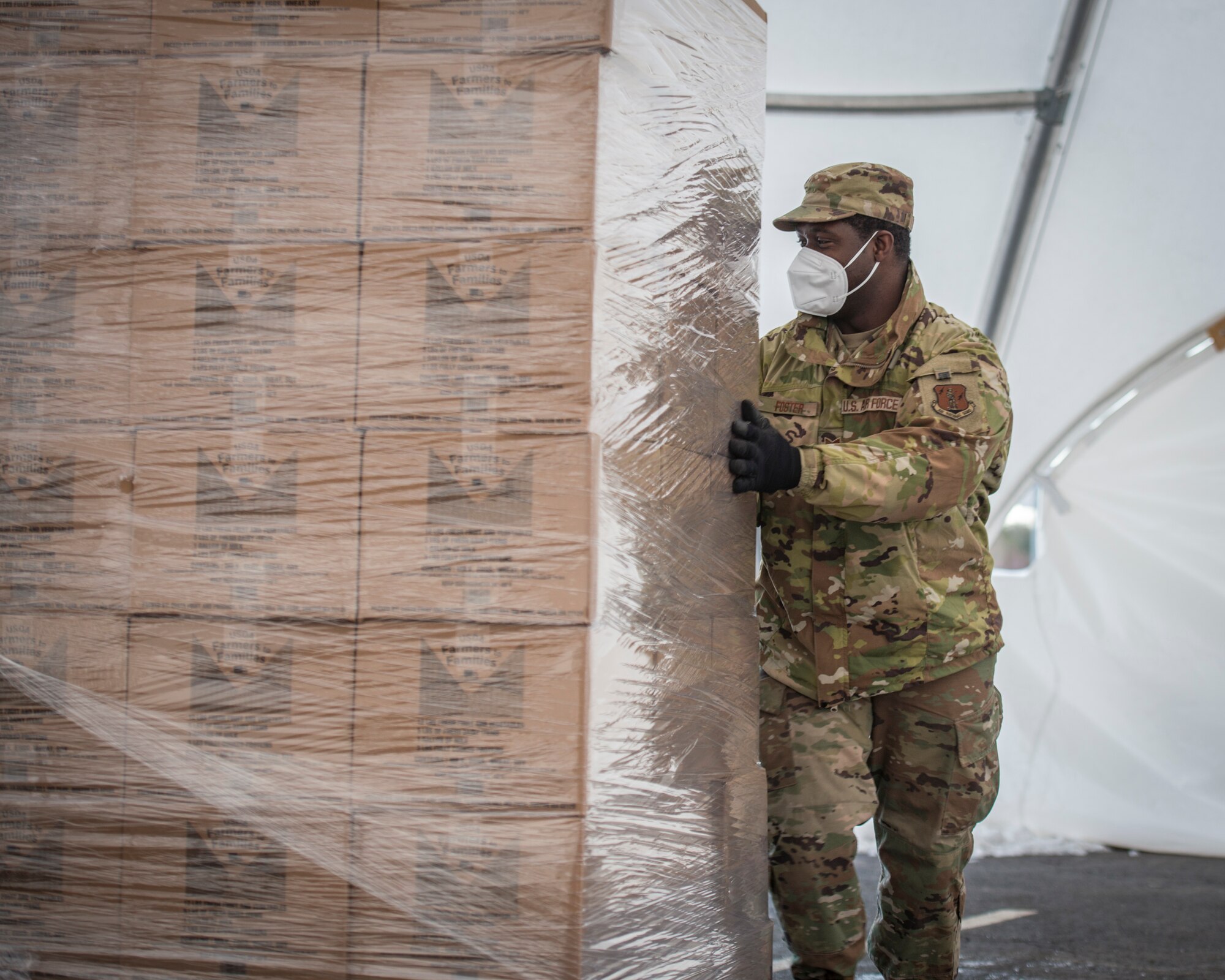 U.S. Air Force Staff Sgt. Melbourne Foster, 103rd Civil Engineer Squadron, prepares U.S. Department of Agriculture Farmers to Families food boxes for distribution at Rentschler Field in East Hartford, Connecticut, Feb. 4, 2021. Airmen from the Connecticut National Guard’s 103rd Airlift Wing are supporting logistics operations at Foodshare’s drive-thru emergency distribution site here, which has distributed over 8,000,000 pounds of food to 233,000 cars since April 20, 2020. (U.S. Air National Guard photo by Staff Sgt. Steven Tucker)