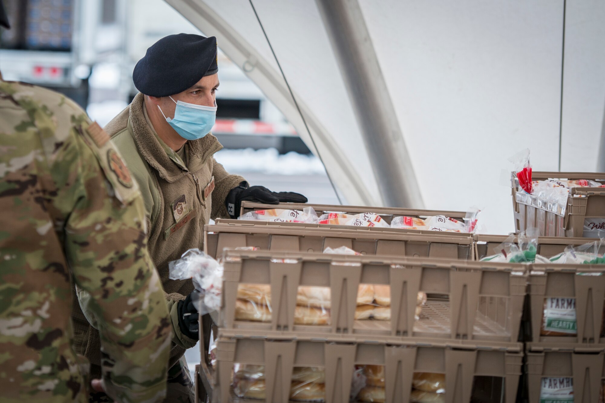 U.S. Air Force Master Sgt. Ian McMahon, 103rd Security Forces Squadron, organizes bread trays for distribution at Rentschler Field in East Hartford, Connecticut, Feb. 4, 2021. Airmen from the Connecticut National Guard’s 103rd Airlift Wing are supporting logistics operations at Foodshare’s drive-thru emergency distribution site here, which has distributed over 8,000,000 pounds of food to 233,000 cars since April 20, 2020. (U.S. Air National Guard photo by Staff Sgt. Steven Tucker)