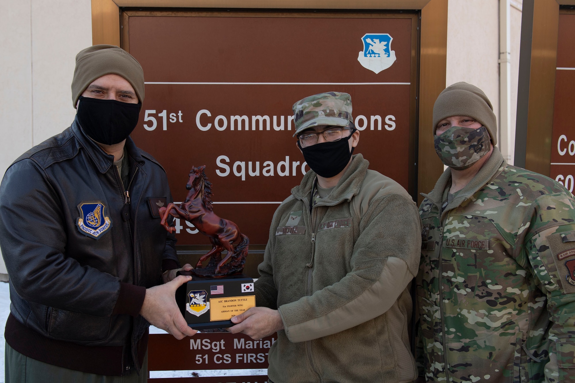 Airman 1st Class Brandon Tuttle, 51st Mission Support Group, middle, receives Airman of the Year honors from 51st Fighter Wing leadership during the 51st Fighter Wing annual awards presentation, Feb. 4, 2021, at Osan Air Base, Republic of Korea. Team Osan unconventionally celebrated the ceremony by visiting the winner’s work centers to emphasize teamwork and camaraderie. (U.S. Air Force photo by Senior Airman Greg Nash)