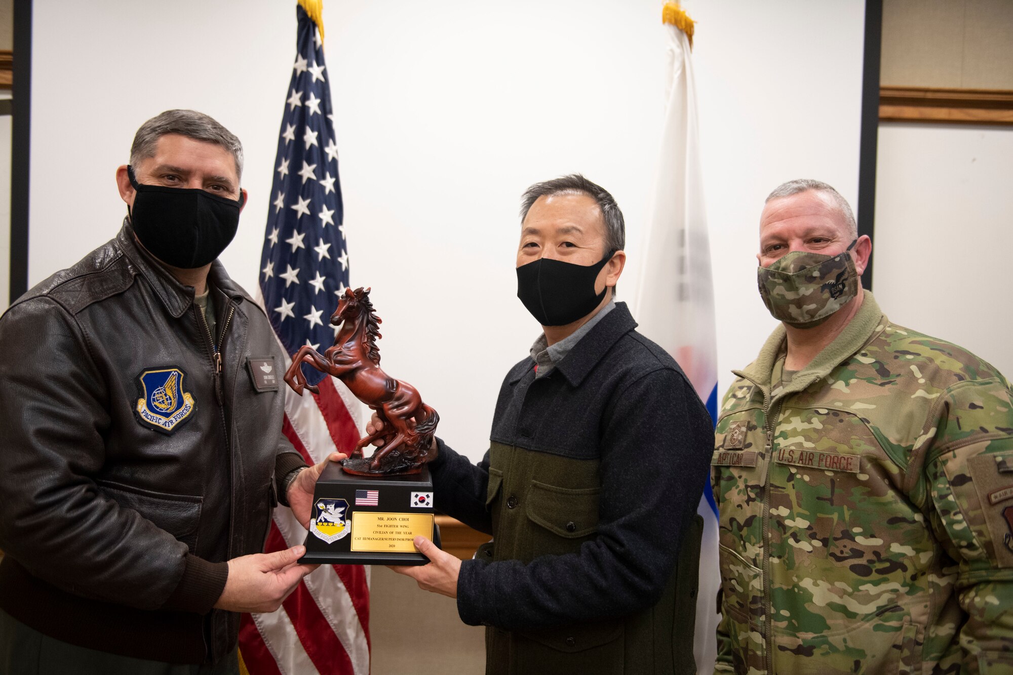 Mr. Joon Choi, 51st Mission Support Group, middle, receives Civilian Category III of the Year honors from 51st Fighter Wing leadership during the 51st Fighter Wing annual awards presentation, Feb. 4, 2021, at Osan Air Base, Republic of Korea. Team Osan unconventionally celebrated the ceremony by visiting the winner’s work centers to emphasize teamwork and camaraderie. (U.S. Air Force photo by Senior Airman Greg Nash)