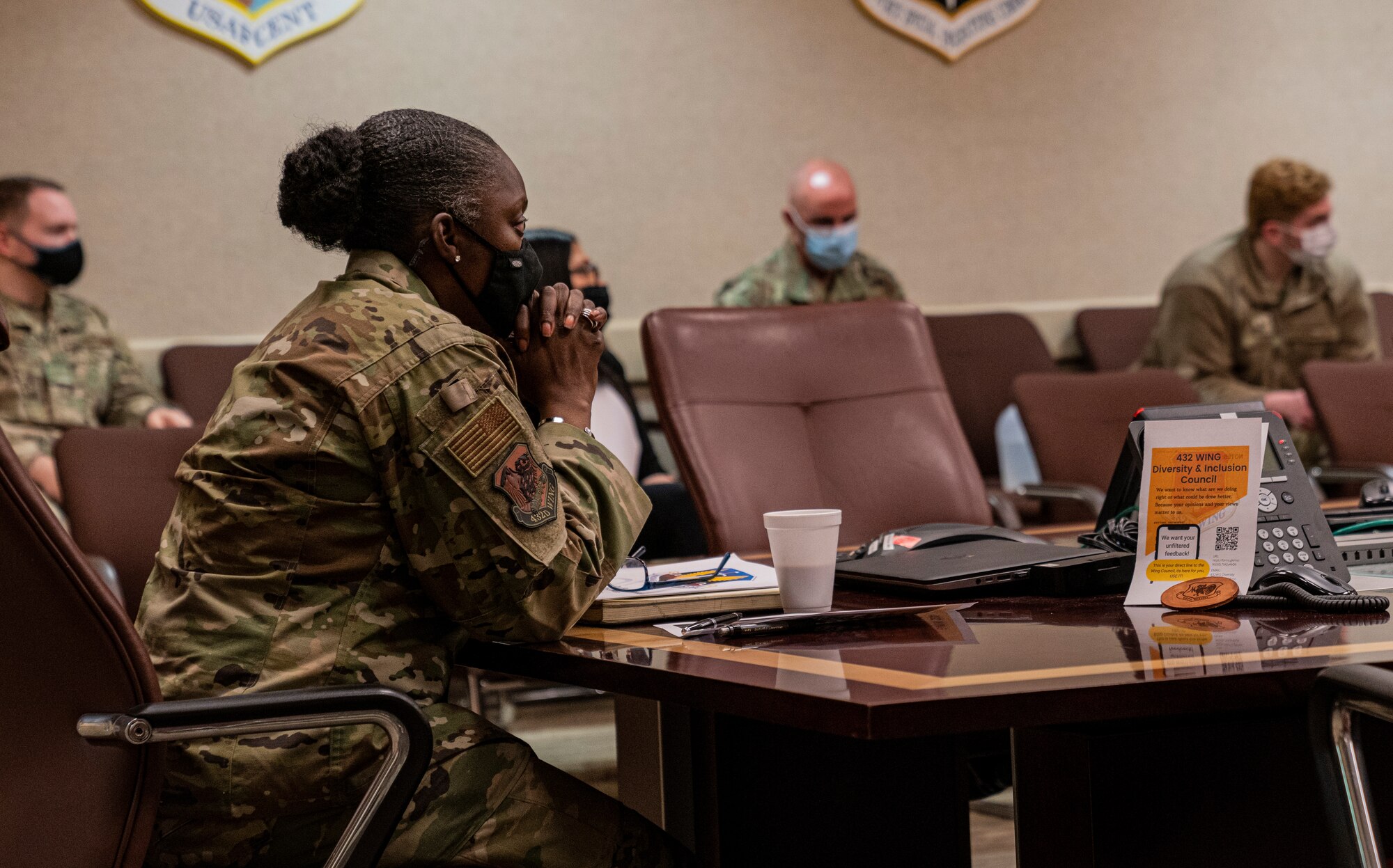 Chief Master Sgt. Michelle Browning, 432nd Wing/432nd Air Expeditionary Wing command chief clasps her hands as she listens to members of the Diversity and Inclusion Council