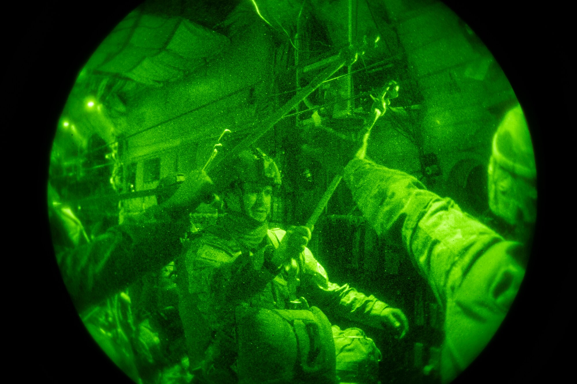 Army paratroopers stand in the back of a C-130.