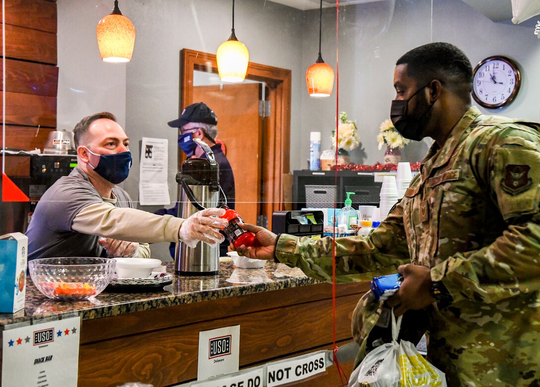 John Giamellow, United Services Organizations volunteer, hands out drinks to service members during the USO 80th birthday celebration at Dover Air Force Base, Delaware, Feb. 4, 2021. USO Delaware celebrated its 80th birthday by providing service members a grab and go lunch, dessert and a tailgating essentials raffle. (U.S. Air Force photo by Airman 1st Class Stephani Barge)