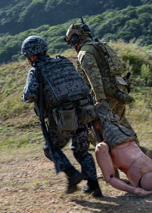 U.S. Air Force and Koku Jieitai defenders work together to drag a simulated wounded troop to saftey during Pacific Defender 21-1 on Andersen Air Force Base, Guam, January 29, 2021
