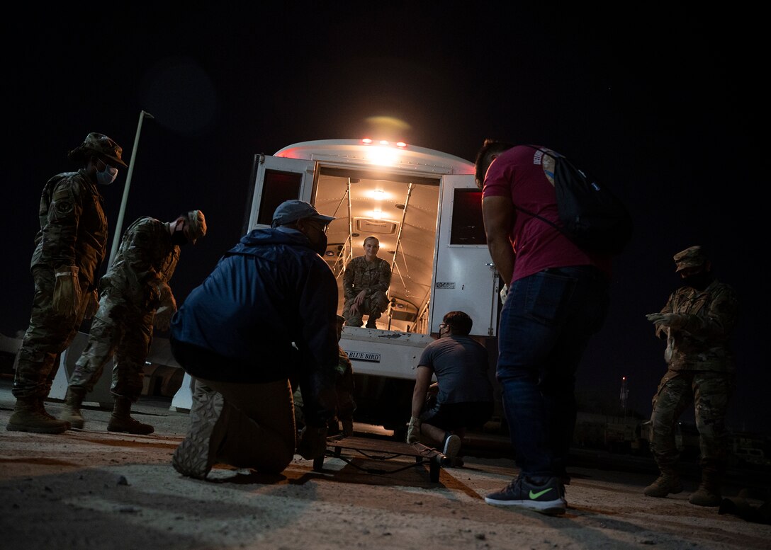 Participants in the 380th Air Expeditionary Wing Honorary Members Program prepare to lift a stretcher into an ambulance bus during a 380th Expeditionary Medical Group (EMDG) immersion event at Al Dhafra Air Base, United Arab Emirates, Jan. 28, 2021.