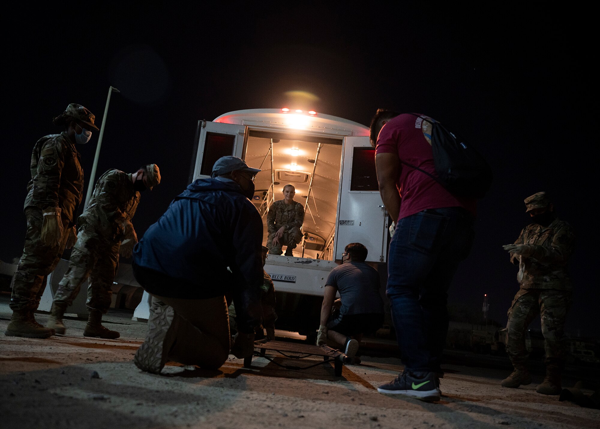 Participants in the 380th Air Expeditionary Wing Honorary Members Program prepare to lift a stretcher into an ambulance bus during a 380th Expeditionary Medical Group (EMDG) immersion event at Al Dhafra Air Base, United Arab Emirates, Jan. 28, 2021.
