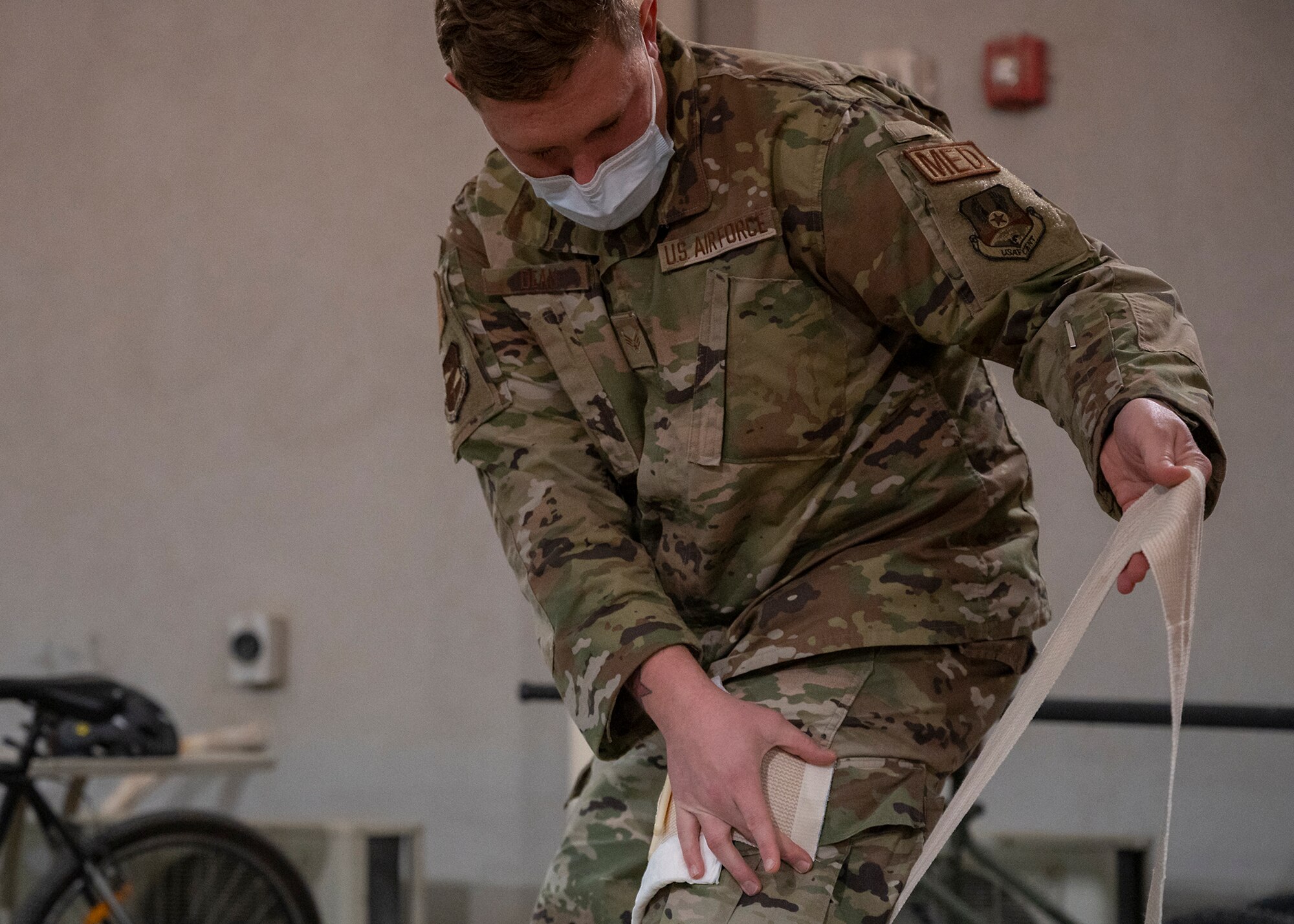 U.S. Air Force Senior Airman Kevin Dean, 380th Expeditionary Medical Group (EMDG) technician, demonstrates self-aid buddy care during a 380th EMDG immersion event at Al Dhafra Air Base, United Arab Emirates, Jan. 28, 2021.