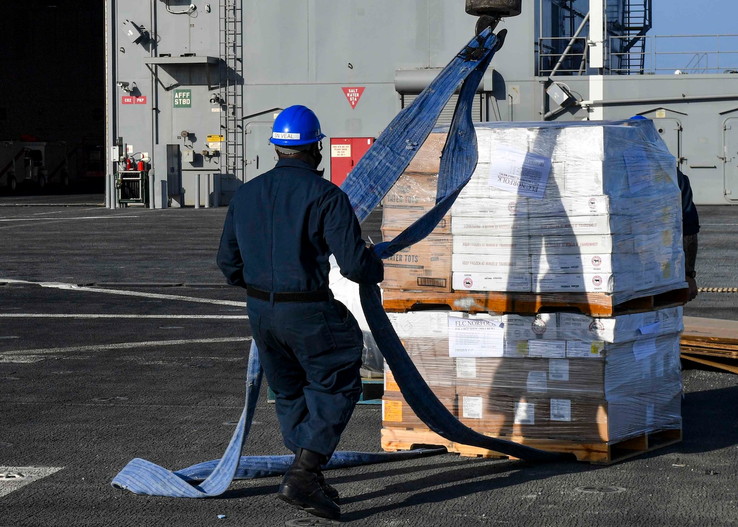 210201-N-GW139-2055
CAMP LEMMONIER, Djibouti (February 01, 2021) Seaman Lamacio Veal removes hoisting straps from palleted goods during a replenishment event pierside before getting underway on board the Expeditionary Sea Base USS Hershel “Woody” Williams (ESB 4) from Port of Djibouti, Feb. 1, 2021. Hershel Williams made final preparations before getting underway in the Sixth Fleet Area of Operations to conduct interoperability training with their African partners and Allied nations. (U.S. Navy photo by Mass Communication Specialist 2nd Class Eric Coffer/Released)