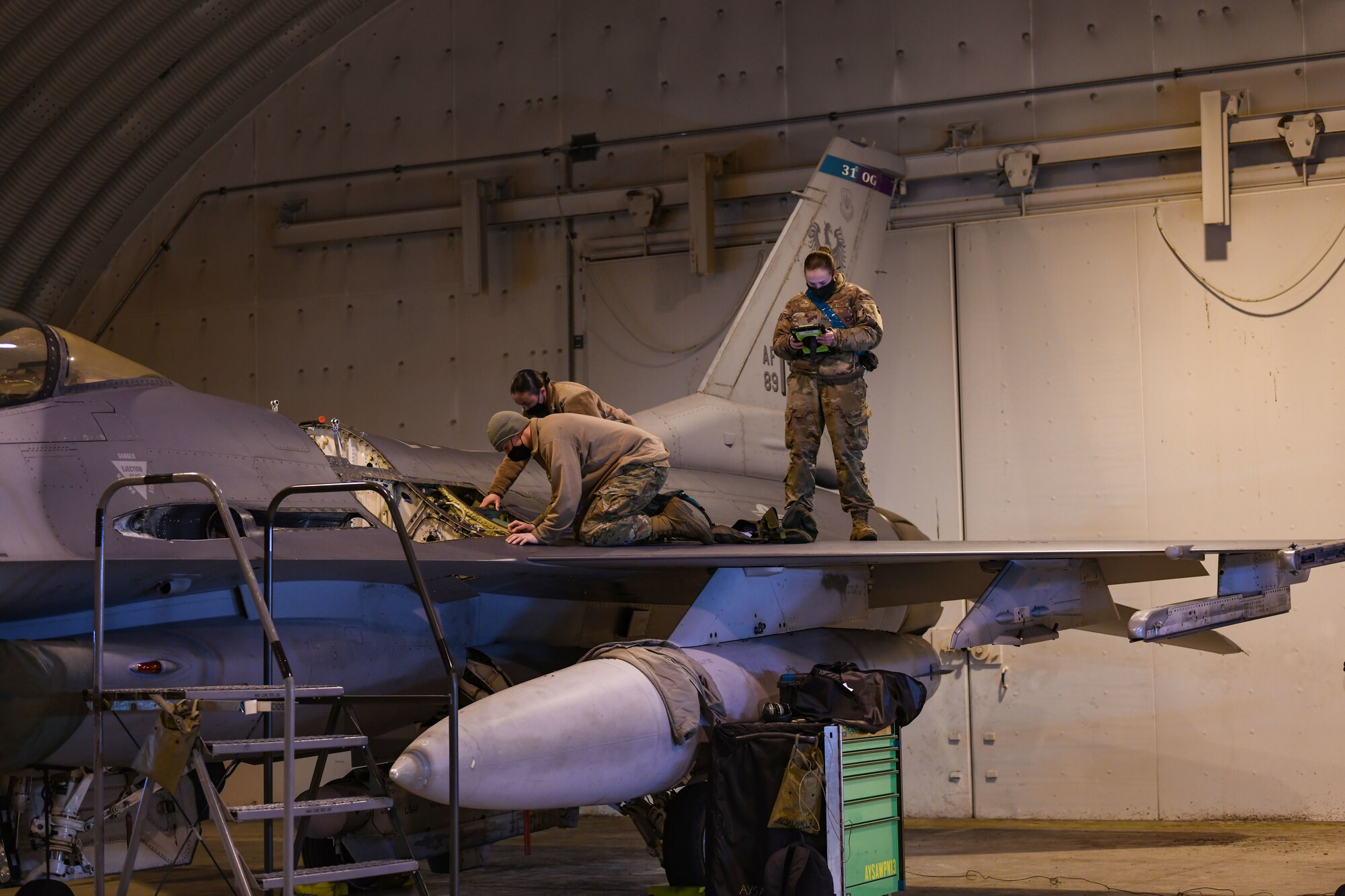 U.S. Air Force Senior Airman Zachary Semmer, 31st Aircraft Maintenance Squadron weapons load crew member, left, Tech. Sgt. Nicole Almario, 31st AMXS weapons load crew chief, center, and Airman 1st Class Kayla Caswell, 31st AMXS weapons load crew member, right, perform an inspection on an F-16 Fighting Falcon at Aviano Air Base, Italy, Feb. 1, 2021. The 31st AMXS supports the 31st Fighter Wing, U.S. Air Forces in Europe and NATO contingency and combat aircraft maintenance requirements. (U.S. Air Force photo by Senior Airman Ericka A. Woolever)