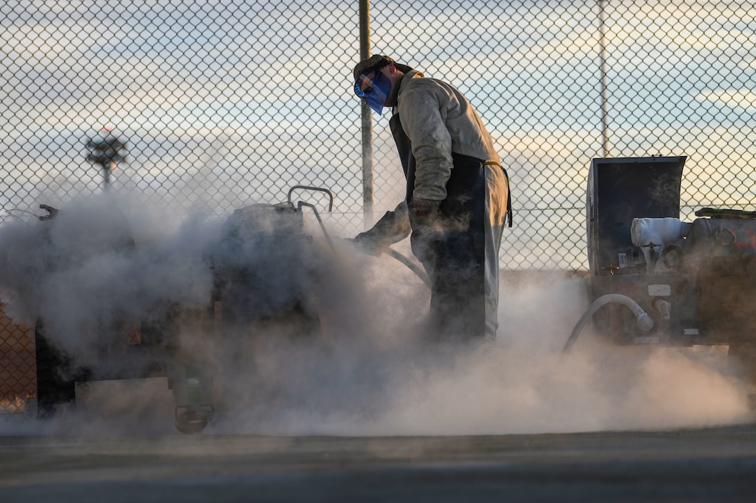 U.S. Air Force Airman 1st Class Jonah Schuline, 31st Aircraft Maintenance Squadron crew chief, services liquid oxygen (LOX) bottles for multiple F-16 Fighting Falcons at Aviano Air Base, Italy, Feb. 1, 2021. LOX is pressurized oxygen that is cooled to minus 297 degrees Fahrenheit, turning it into a boiling liquid. Ramirez wore a face shield, coveralls, gloves, and boots to protect his skin from contact burns. (U.S. Air Force photo by Senior Airman Ericka A. Woolever)