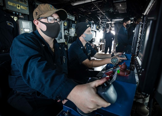 Gunner’s Mate 3rd Class Carter Musgrave, left, from Zanesville, Ohio, and Gunner’s Mate 3rd Class Brayden Barthel, from Hagerstown, Md., track surface contacts through mark-38 25mm gun remote operator consoles in the pilot house aboard the Arleigh Burke-class guided-missile destroyer USS John S. McCain (DDG 56).