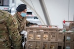 U.S. Air Force Master Sgt. Ian McMahon, 103rd Security Forces Squadron, organizes bread trays for distribution at Rentschler Field in East Hartford, Connecticut, Feb. 4, 2021. Airmen from the Connecticut National Guard’s 103rd Airlift Wing are supporting logistics operations at Foodshare’s drive-thru emergency distribution site.