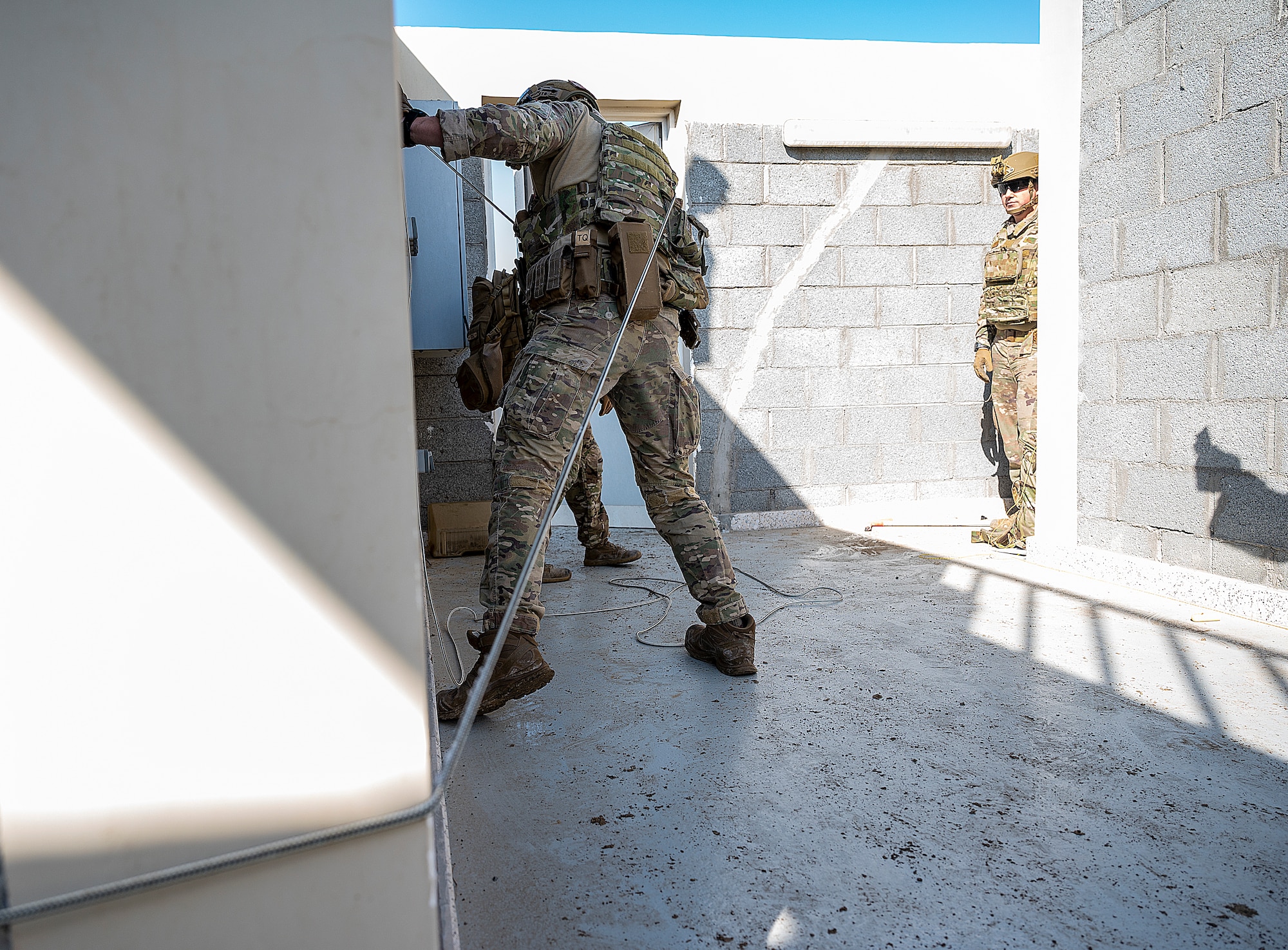 U.S. Air Force Staff Sgt. Ryan Melody, 380th Expeditionary Civil Engineer Squadron explosive ordnance disposal (EOD) technician pulls a wire during a simulated explosive removal training at Al Dhafra Air Base, United Arab Emirates, Jan. 28, 2021.