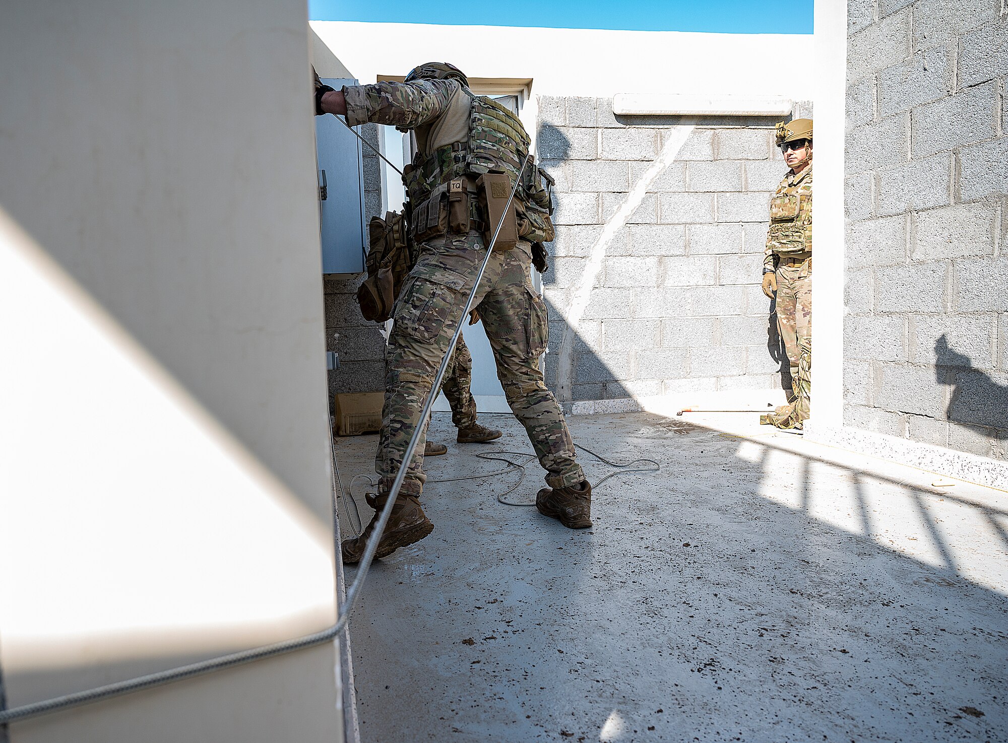 U.S. Air Force Staff Sgt. Ryan Melody, 380th Expeditionary Civil Engineer Squadron explosive ordnance disposal (EOD) technician pulls a wire during a simulated explosive removal training at Al Dhafra Air Base, United Arab Emirates, Jan. 28, 2021.