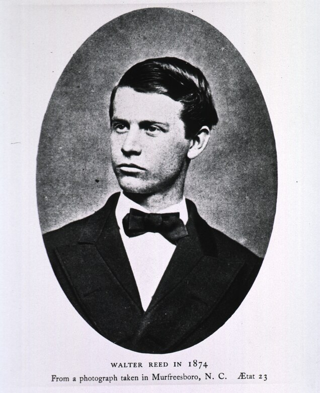 An oval photo shows a young man in a suit and bow tie.