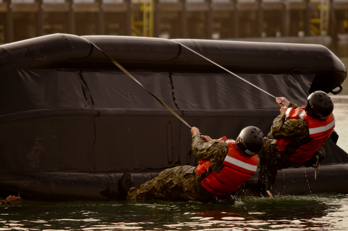 CORONADO, Calif. (June 2, 2020) Special Warfare Combatant-Craft Crewman (SWCC) candidates from Basic Crewman Selection (BCS) Class 111 flip their Combat Rubber Raiding Craft (CRRC) after dumping it during “The Tour” at Naval Special Warfare (NSW) Center in Coronado, Calif., June 2, 2020. The Tour is a 72-hour crucible event, which develops intelligent and highly-motivated candidates who will perform as a team under the most demanding conditions. NSW Center provides initial and advanced training to the Sailors who make up the Navy’s SEAL and Special Boat Teams. This photo has been altered by obscuring names for security purposes. (U.S. Navy Photo by Mass Communication Specialist 1st Class Anthony W. Walker/Released)