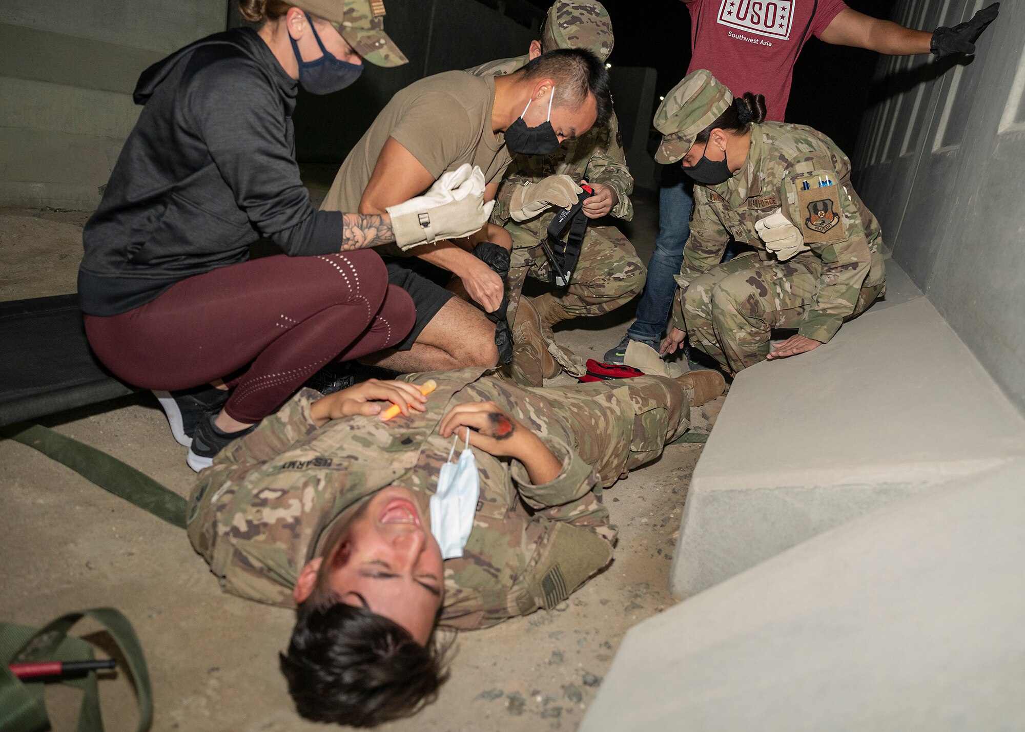 Participants in the 380th Air Expeditionary Wing Honorary Members Program perform self-aid buddy care on a U.S. Army soldier with simulated injuries during a 380th Expeditionary Medical Group (EMDG) immersion event at Al Dhafra Air Base, United Arab Emirates, Jan. 28, 2021.