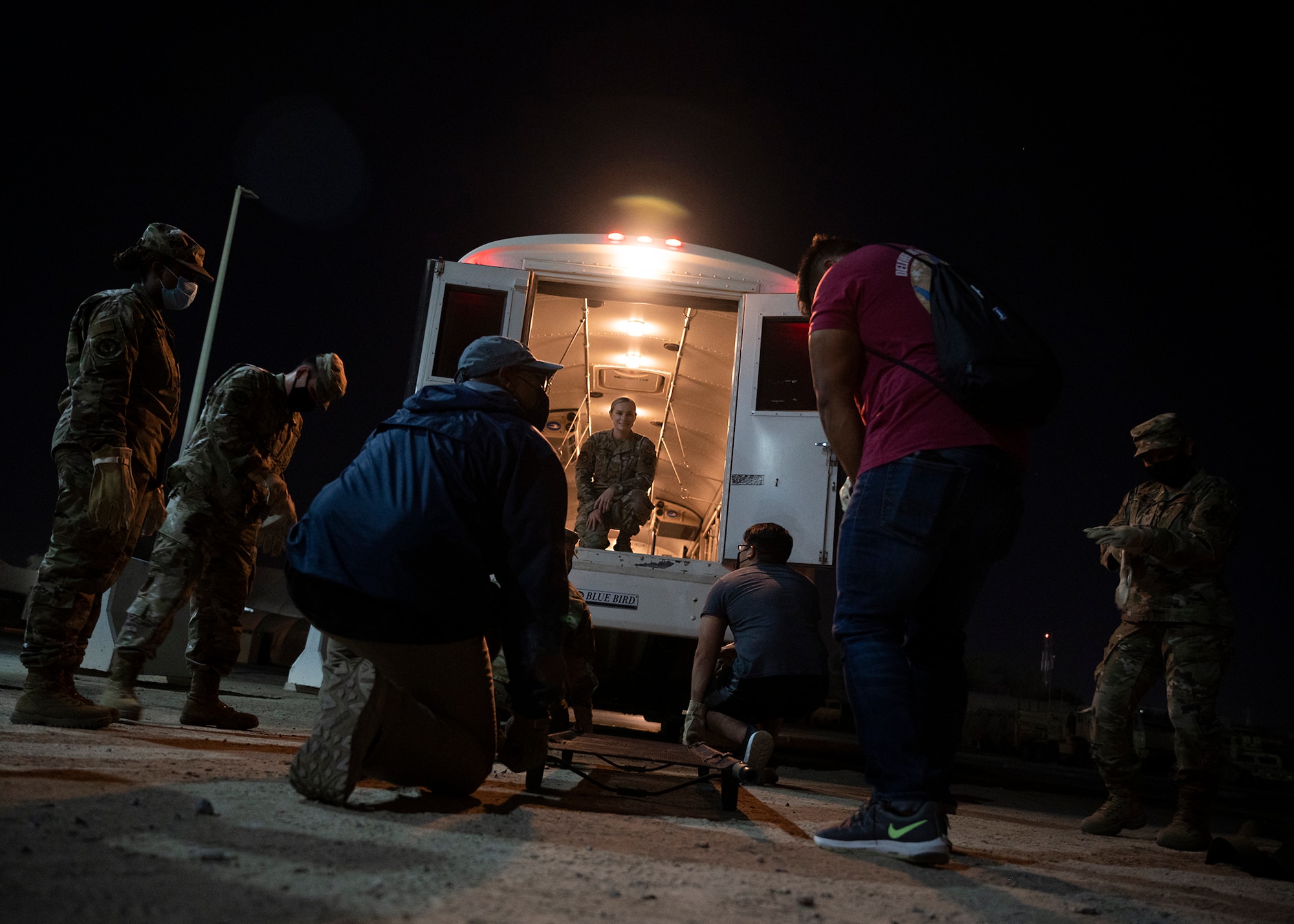 Participants in the 380th Air Expeditionary Wing Honorary Members Program prepare to lift a stretcher into an ambulance bus during a 380th Expeditionary Medical Group (EMDG) immersion event at Al Dhafra Air Base, United Arab Emirates, Jan. 28, 2021.