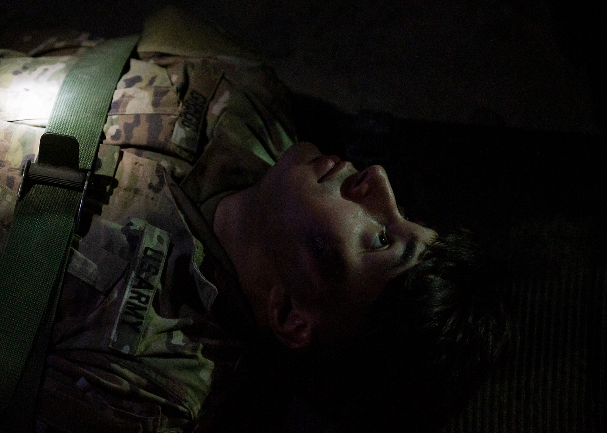 U.S. Army Specialist Jayson Gregg, 5-52 Air Defense Artillery combat medic, prepares to be lifted on a stretcher during a 380th Expeditionary Medical Group immersion event at Al Dhafra Air Base, United Arab Emirates, Jan. 28, 2021.