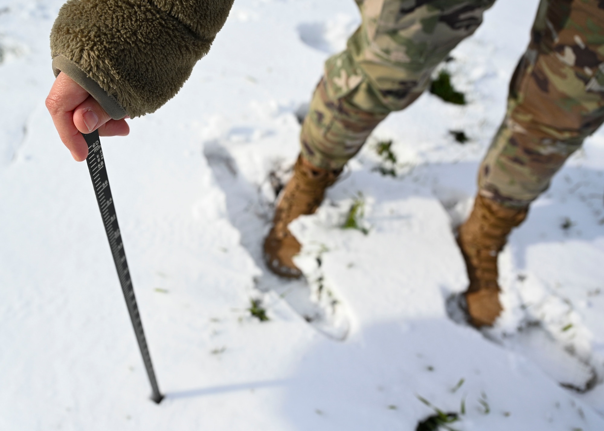Airman measuring snow