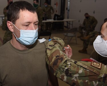 Sgt. Kevin LaPierre receives his second dose of COVID-19 vaccine from Lt. Col. Sarah Davis Feb. 3, 2021, at Camp Johnson, Vermont. Recipients of the second dose commonly experience mild flu-like symptoms including soreness and mild fever. LaPierre is a fueler with the Vermont National Guard's 186th Brigade Support Battalion. Davis is a registered nurse and the officer in charge of immunizations for the Vermont Air National Guard's 158th Medical Group.