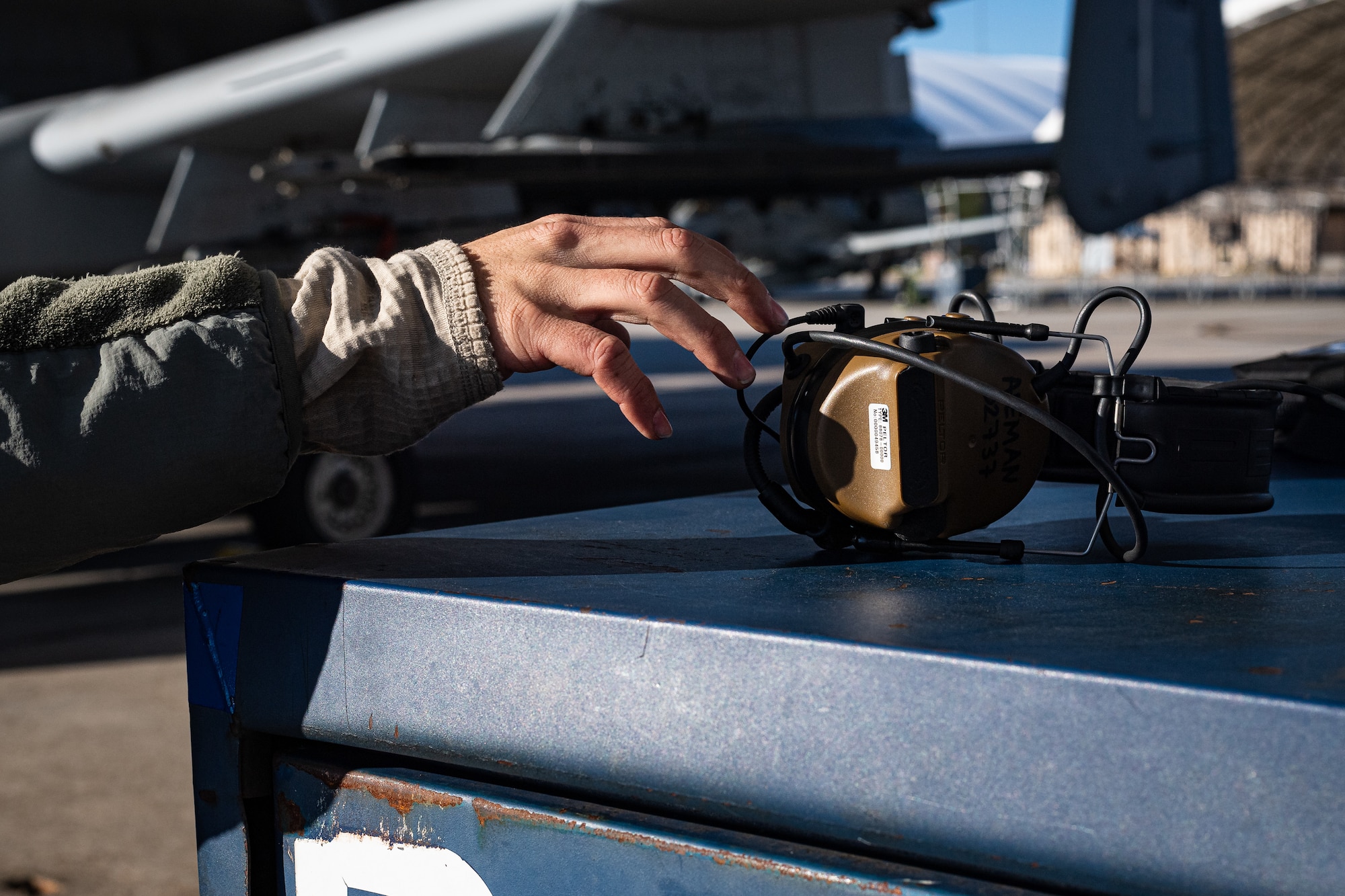 A photo of an Airman reaching for a headset