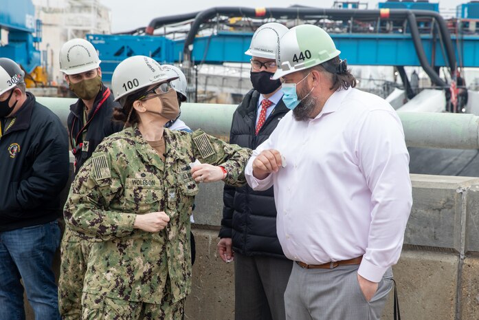 Shipbuilding Specialist Chad Johnson receives his BZ 100 award from Capt. Dianna Wolfson.