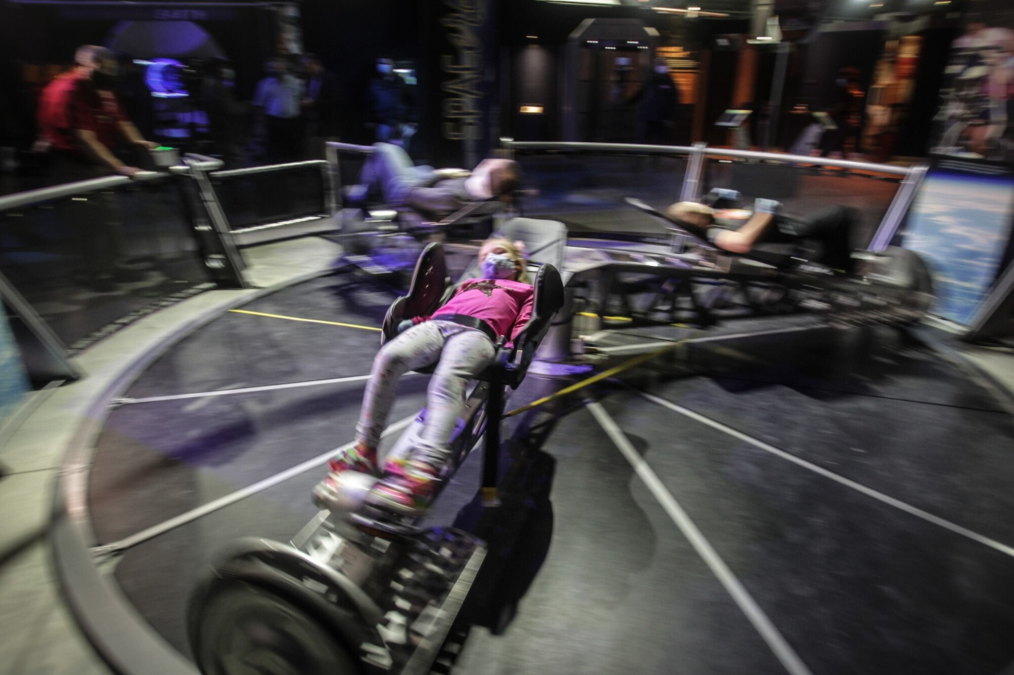 Laney Daniel, from Englewood, rides the space bike at the National Museum of the U.S. Air Force exhibit, "SPACE: A Journey to Our Future." The exhibition features: touching actual rocks from the surface of the Moon and Mars, a Mars Base Camp, habitat, work pod and a centrifuge that is powered by a bicycle along with artifacts from the space program. The exhibition will be open through Labor Day and is free to the public. JIM NOELKER/COX FIRST MEDIA STAFF