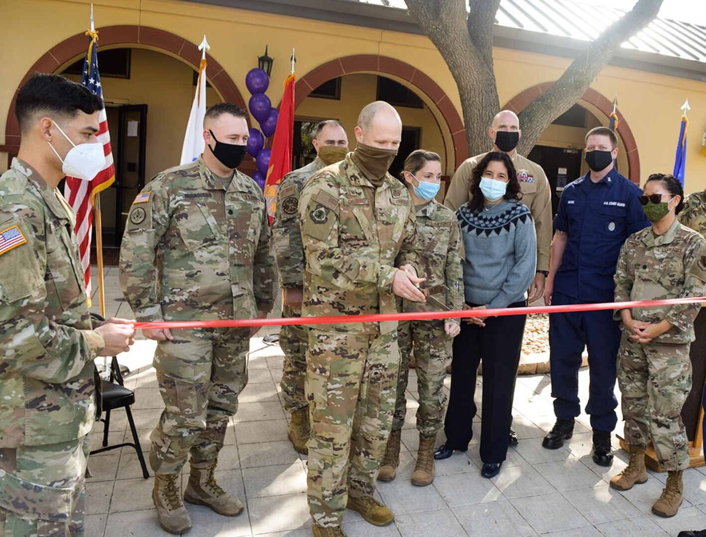 Joint service members stand with U.S. Air Force Col. Ty Gilbert, 543rd Intelligence, Surveillance and Reconnaissance Group commander, as he prepares to cut the ceremonial ribbon and officially open the Joint Collaboration Facility.