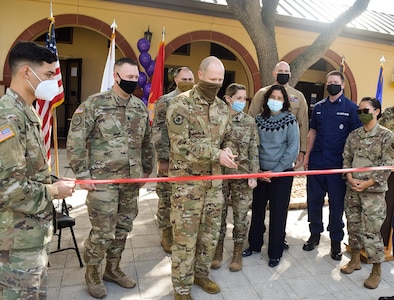 Joint service members stand with U.S. Air Force Col. Ty Gilbert, 543rd Intelligence, Surveillance and Reconnaissance Group commander, as he prepares to cut the ceremonial ribbon and officially open the Joint Collaboration Facility.