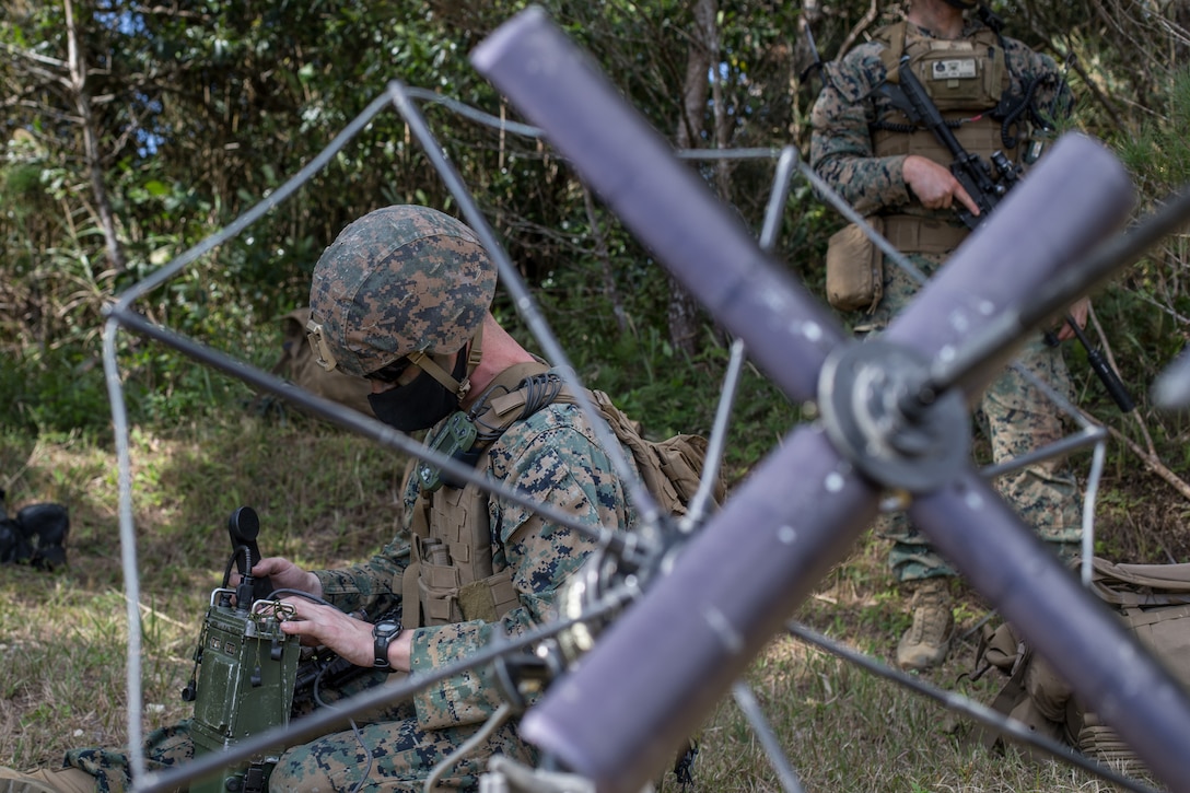 A Marine checks a radio.