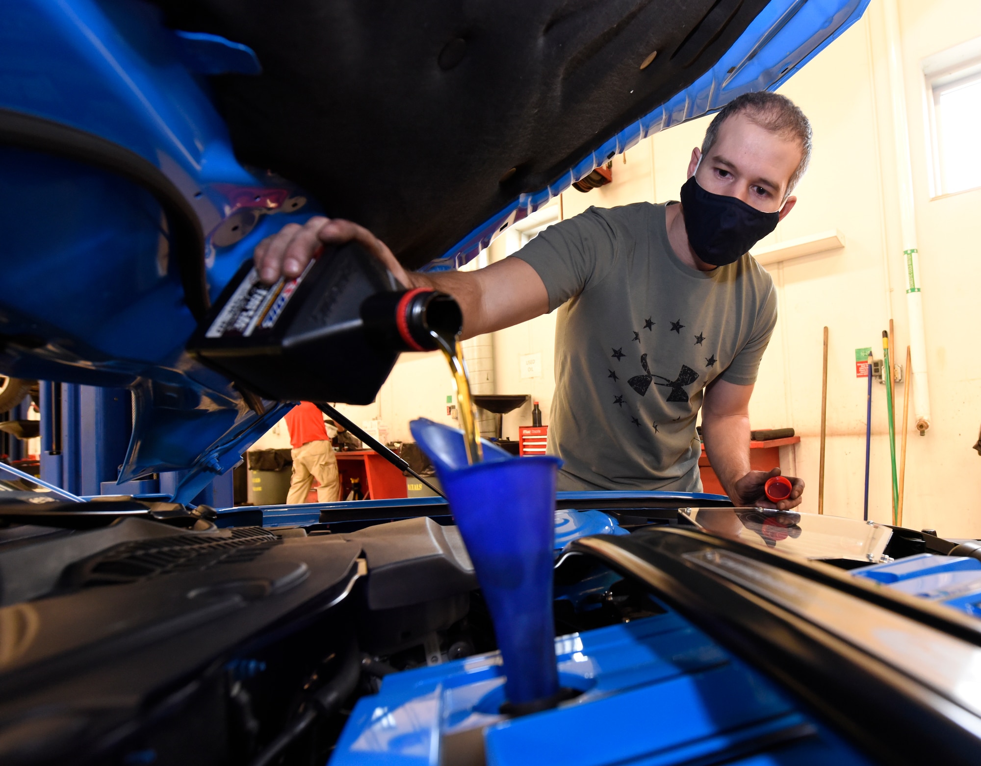 Army veteran Donald Wiggins refills the oil in his Mustang inside the Auto Hobby Shop at Wright-Patterson Air Force Base, Ohio, on Jan. 28, 2021. The Auto Hobby Shop supplies tools and lifts for do-it-yourself repairs and maintenance. It charges a nominal fee by appointment only. The shop is open to personnel who have access to Wright-Patterson Air Force Base. (U.S. Air Force photo by Ty Greenlees