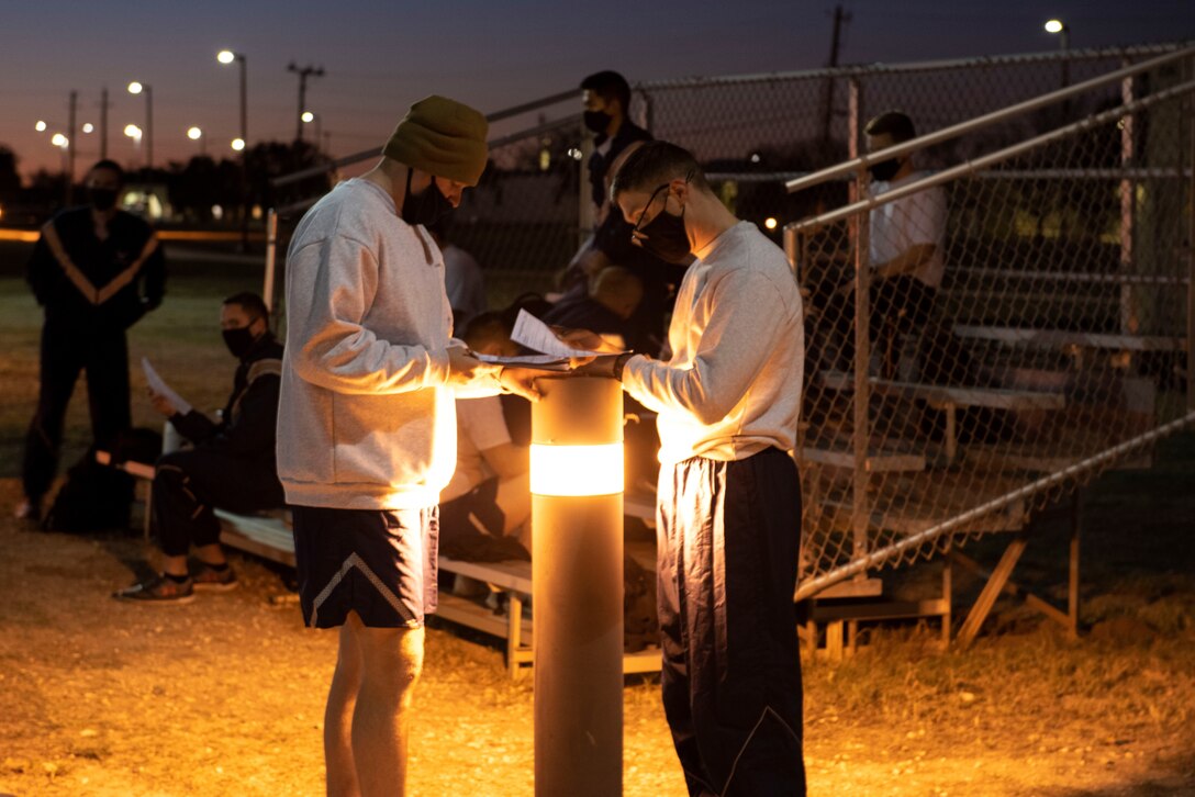 Student pilots filling out forms before starting their morning PT on Feb. 01, 2021 at Laughlin Air Force Base, Texas. During the course the students met at the track for their morning Pt. (U.S. Air Force photo by Airman 1st Class David Phaff)