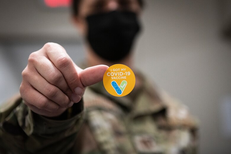 Photo of an Airman holding a sticker