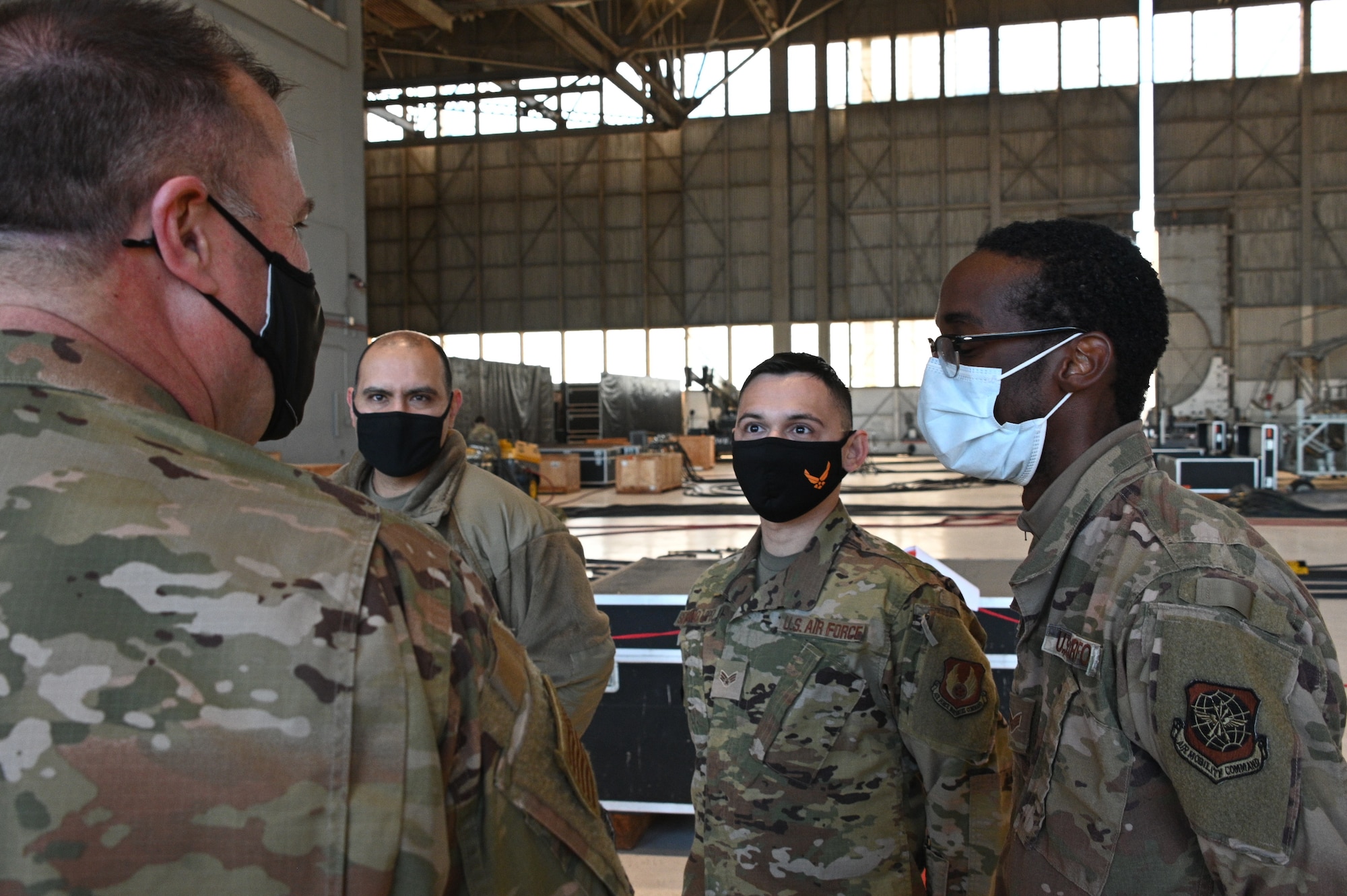 A man in a military uniform talks to other smaller people in military uniforms.