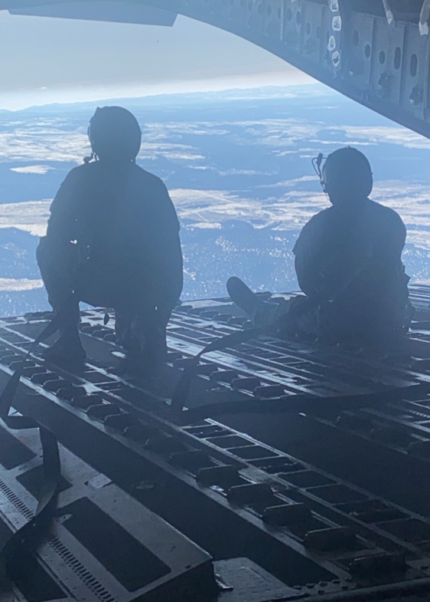 U.S. Air Force Airmen 1st Class Michael Geller, left, and Trevor Marlin, both loadmasters with the 517th Airlift Squadron, look out the open cargo door of a U.S. Air Force C-17A Globemaster III aircraft assigned to the 176th Wing, Alaska Air National Guard, over northwestern Colorado, Jan. 9, 2021. Thirteen Airmen with the 517th AS from Joint Base Elmendorf-Richardson, Alaska, trained for a week in the southwestern U.S. with the C-17, focusing on Agile Combat Employment to train and prepare for global operations in a deployed environment.